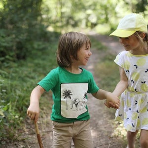two kids holding hands on a trail
