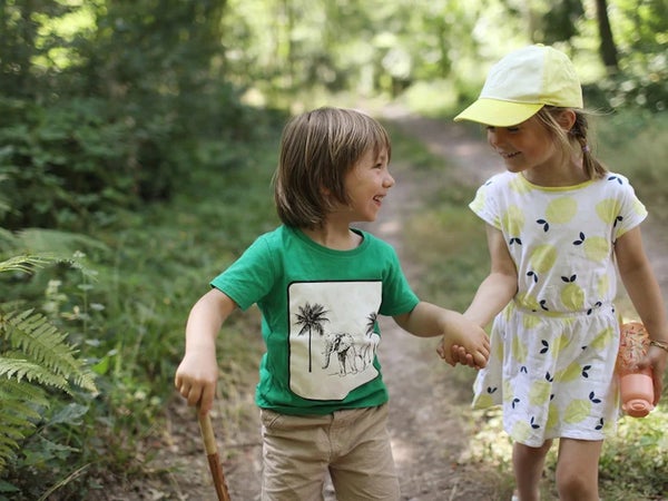 two kids holding hands on a trail