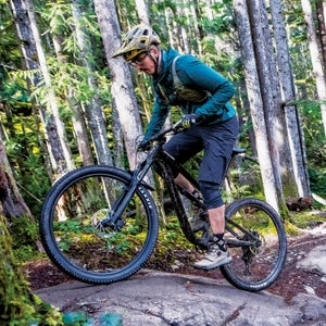 Mountain biker riding over a rock