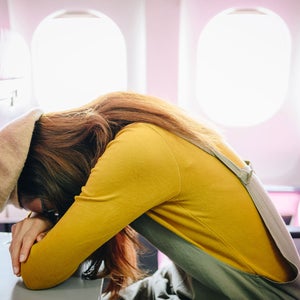 woman sleeping on an airplane tray table
