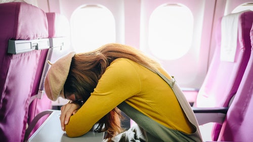 woman sleeping on an airplane tray table