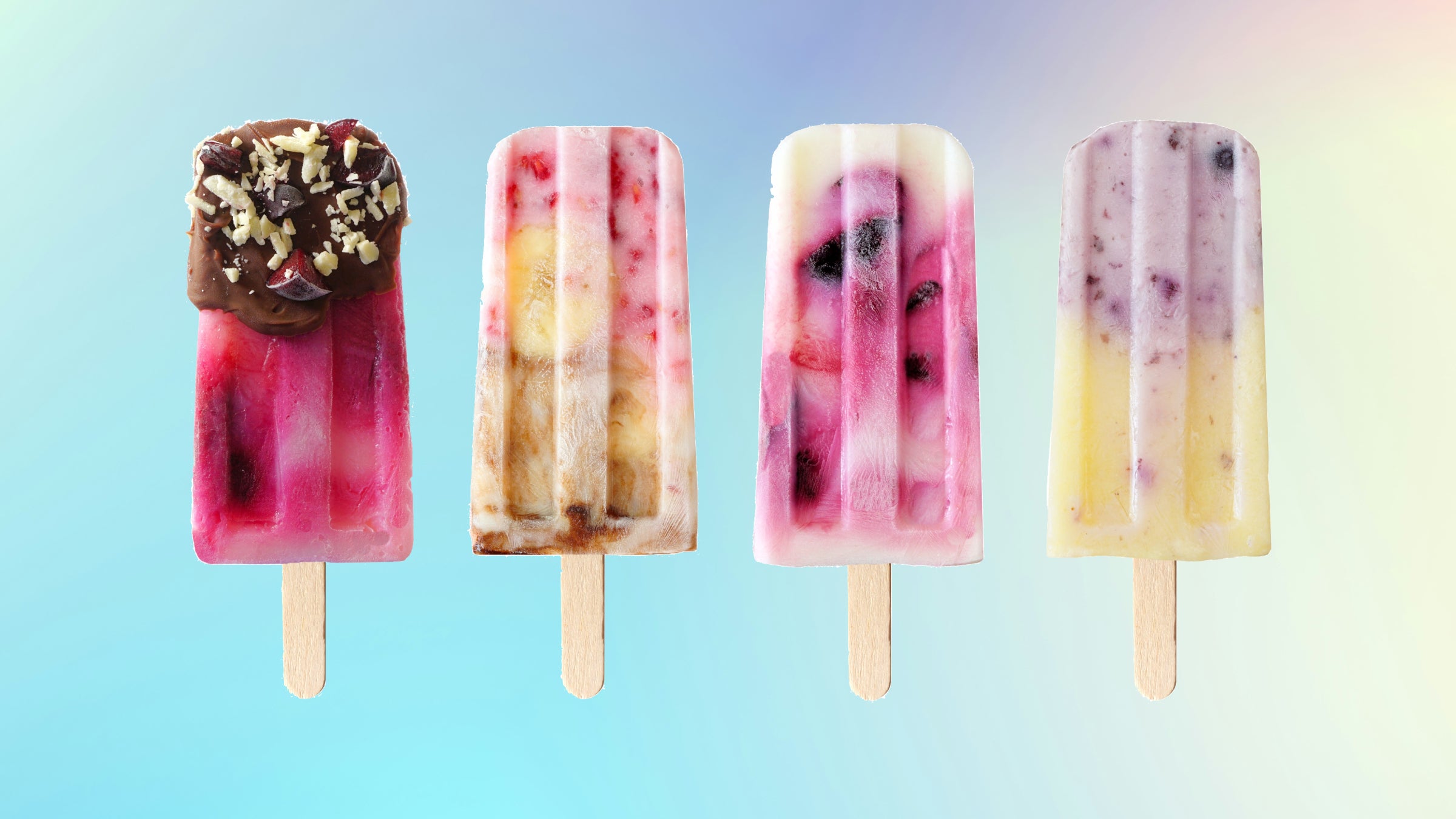 different flavored protein popsicles using banana, blueberry, chocolate, and raspberry on a light gradient background