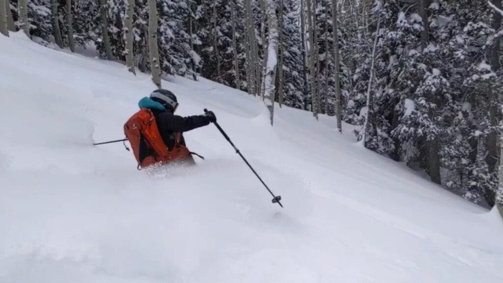 A skier waist-deep in powder plows down a run in Utah’s Wasatch.