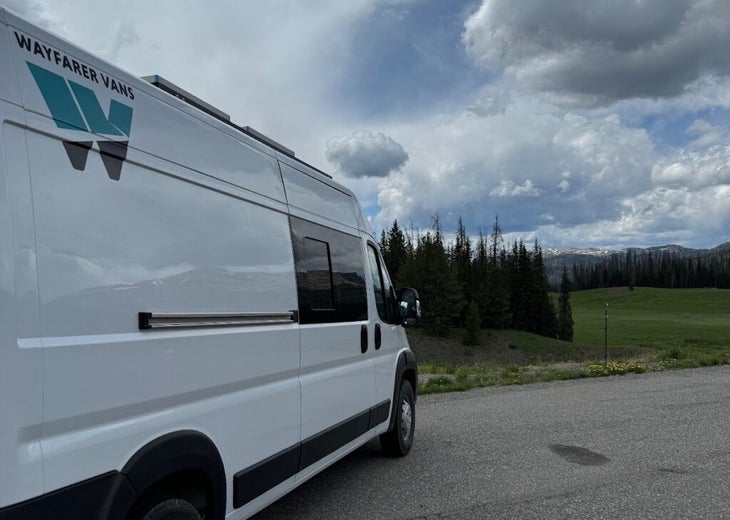 A Ram Promaster with a Wayfarer Vans logo in a parking lot 