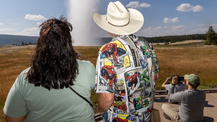 Visitors watch an eruption of Old Faithful in Yellowstone Park Sunday August 11, 2024.