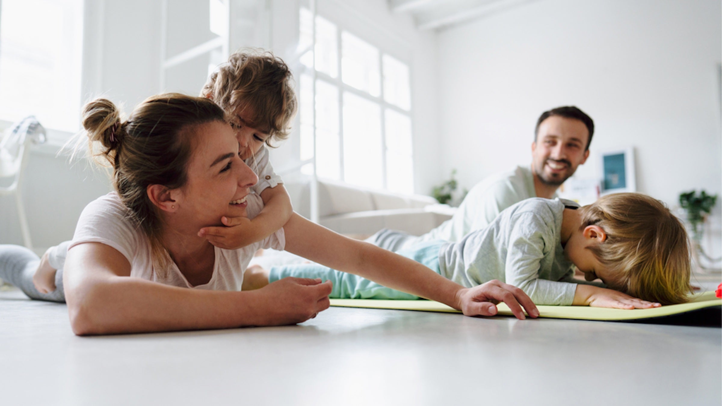 kids doing yoga on mat with parents