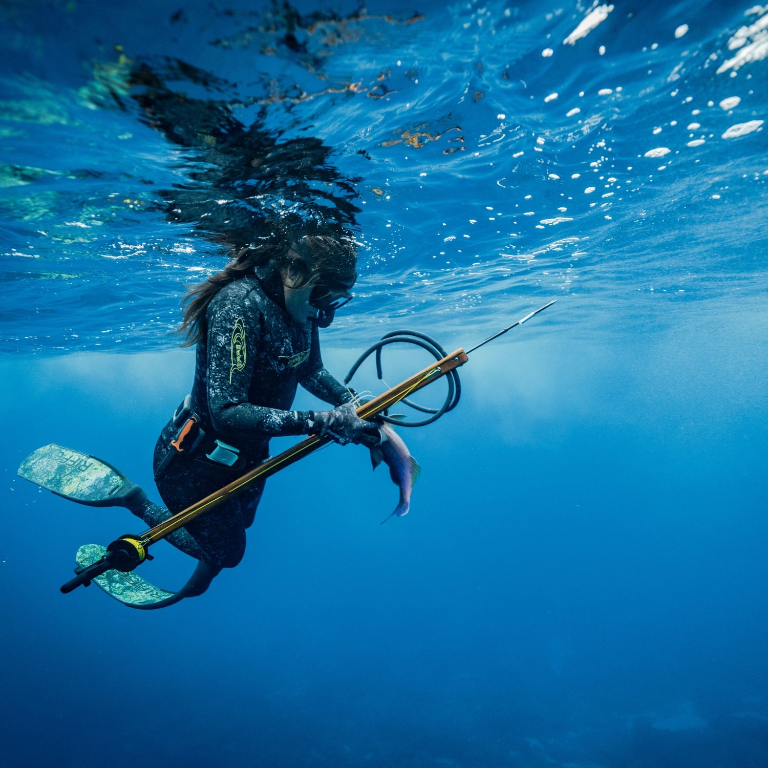 Woman underwater spearfishing