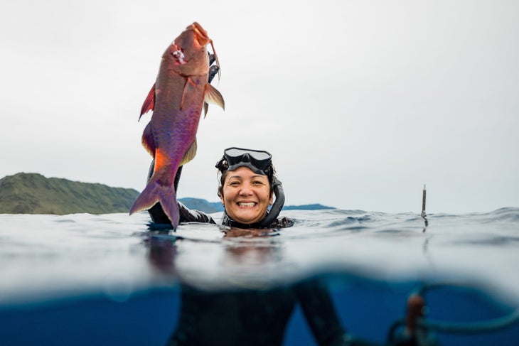 Kimi holds up a Moano (Blue Goatfish) off the north shore of O‘ahu. [Photo: Justin Turkowski]