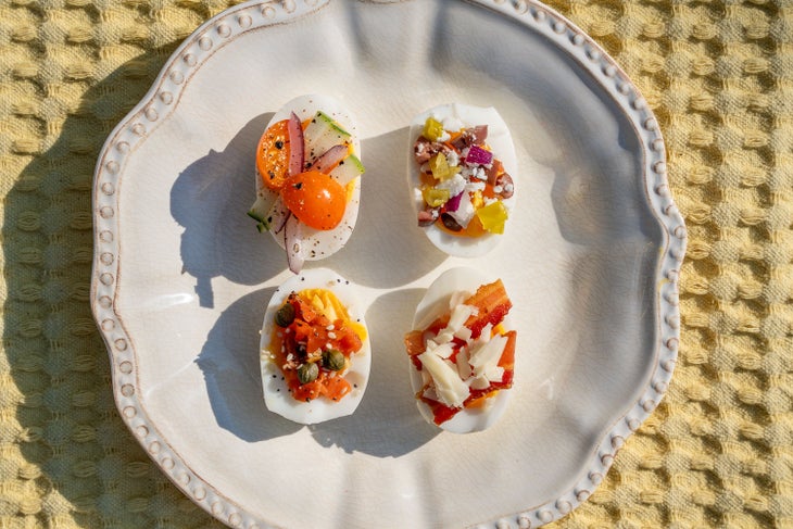 An Egg Flight With Garden Medley (Top Left), Greek Salad (Top Right), Lox and Caper (Bottom Left), and a Bacon and Cheddar (Bottom Right)