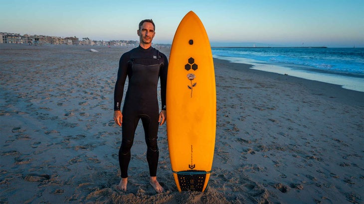 A man standing in a wetsuit by the ocean