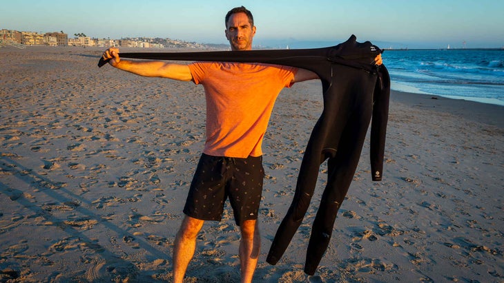 A man stretching a wetsuit