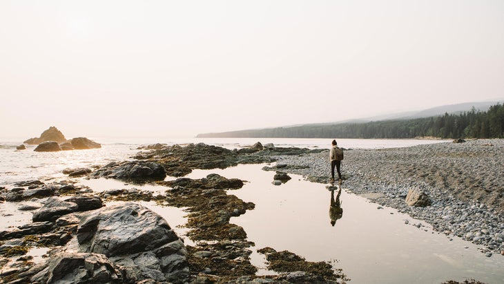 woman walking on a calm day at sombrio beach near jordan river and port renfrew