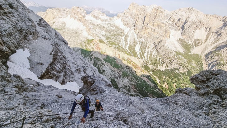 people climbing up a fixed cable on Ferrata Giovanni Lipella in the Italian Dolomites