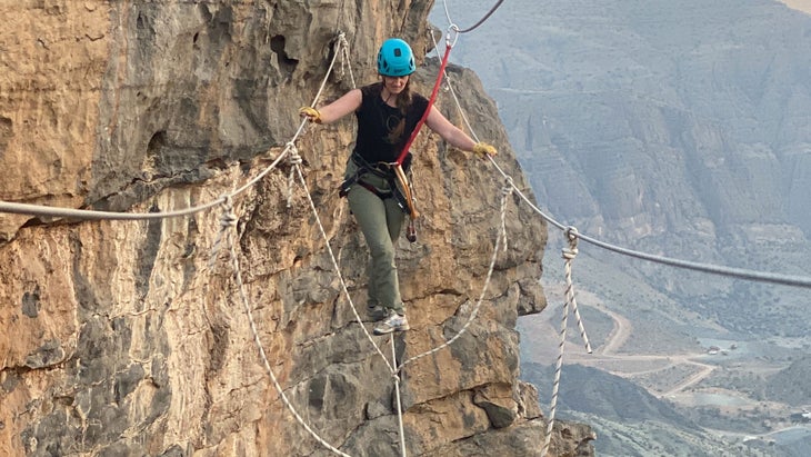 woman crossing a tightrope on Al Jabal Akhdar Via Ferrata in Oman