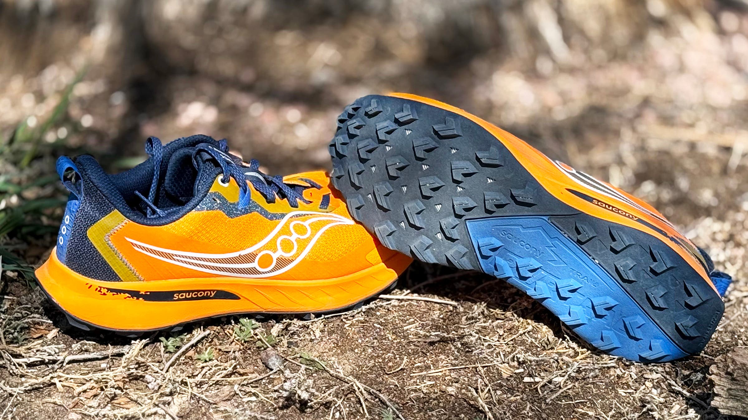 Bright orange and navy Saucony Peregrine 15 trail running shoes tested on trail