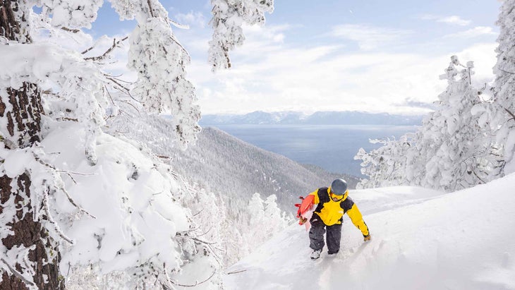 A snowboarder hiking uphill