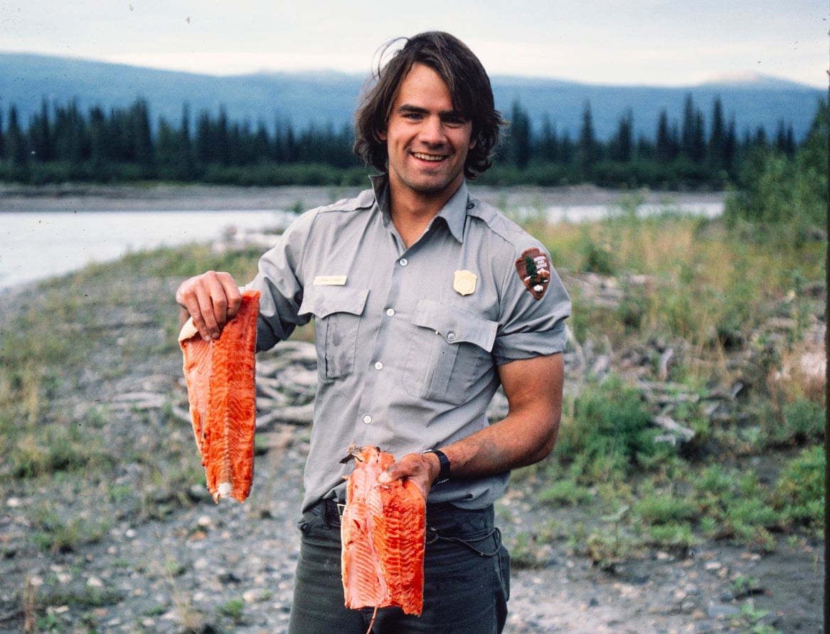 man in arctic holding up salmon filets