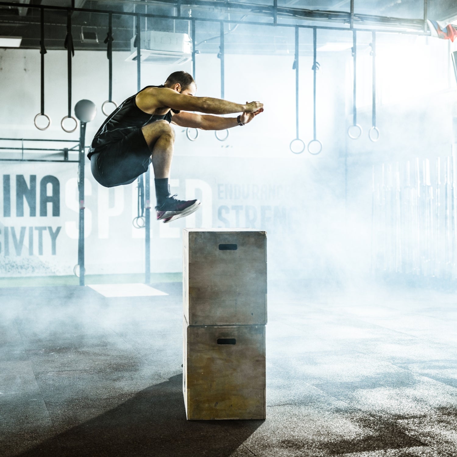 An athlete in midair performing a box jump to increase muscle power