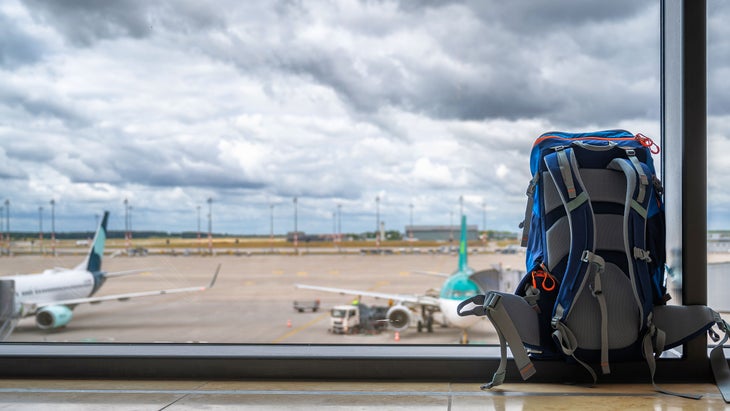 backpacking pack in an airport in front of a plane 