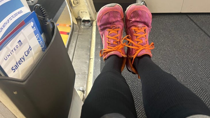 A woman shows off her black compression socks, which pull up to her knees.