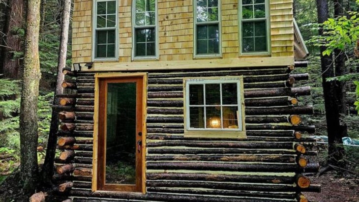 A two-story cabin, the bottom half made of hemlock logs, the top of two-by-fours