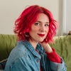 Woman with bright red hair smiling.