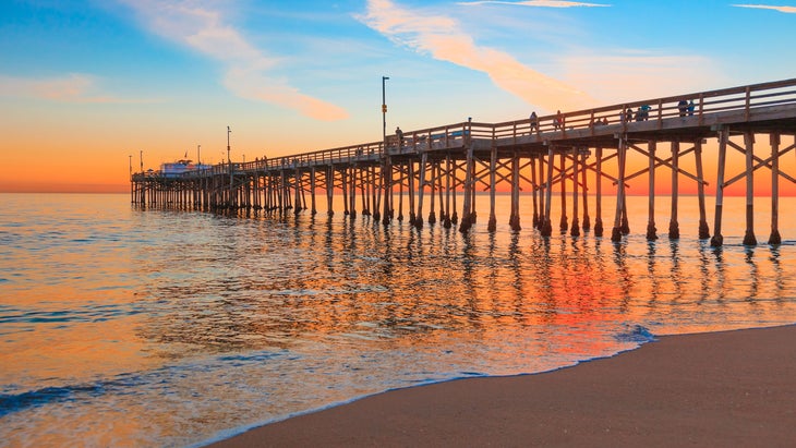 incoming tide reflects the sunset at Balboa Pier in Newport Beach, CA