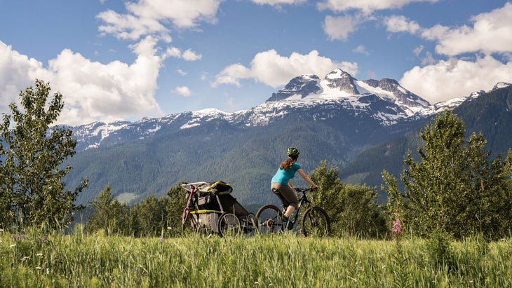 woman mountain biking with her kids in Illecillewaet Greenbelt Trails near Revelstoke