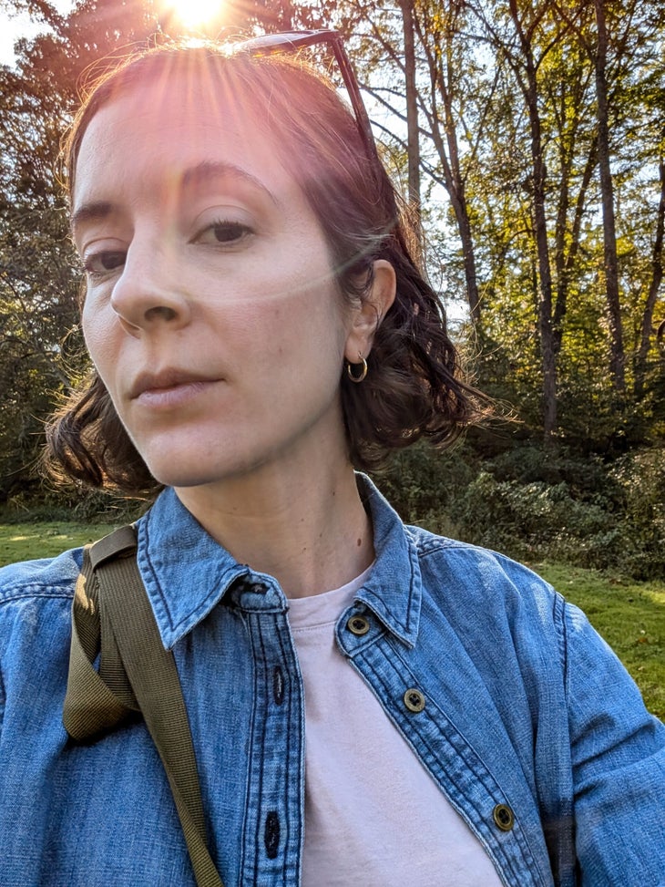 A woman taking a selfie. She shows off her makeup. 