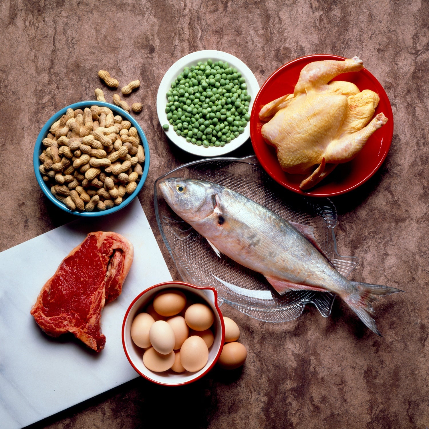 A table featuring many protein sources, including fish, red meat, peas, and eggs.