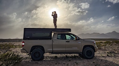Author Bryan Rogala stands atop his truck, camper—and at least one clever truck bed storage solution.