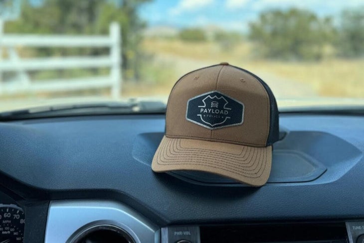 payload police ball cap on a truck dashboard