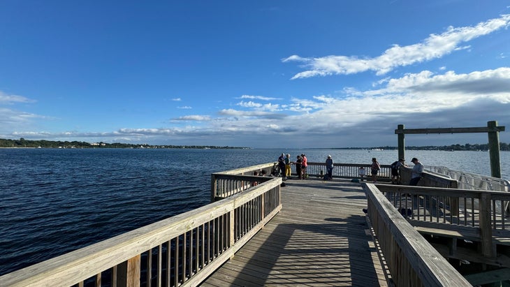 people at the end of a dock looking out at Narragansett Bay