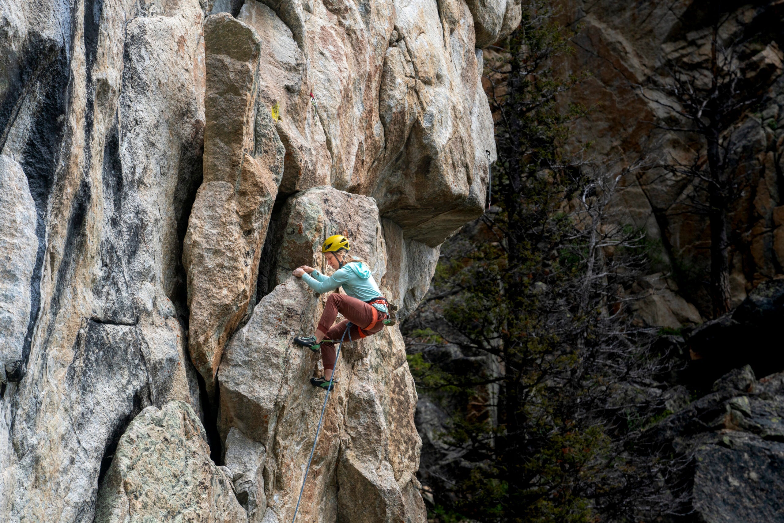 A woman climbs on lead at a crag in Montana