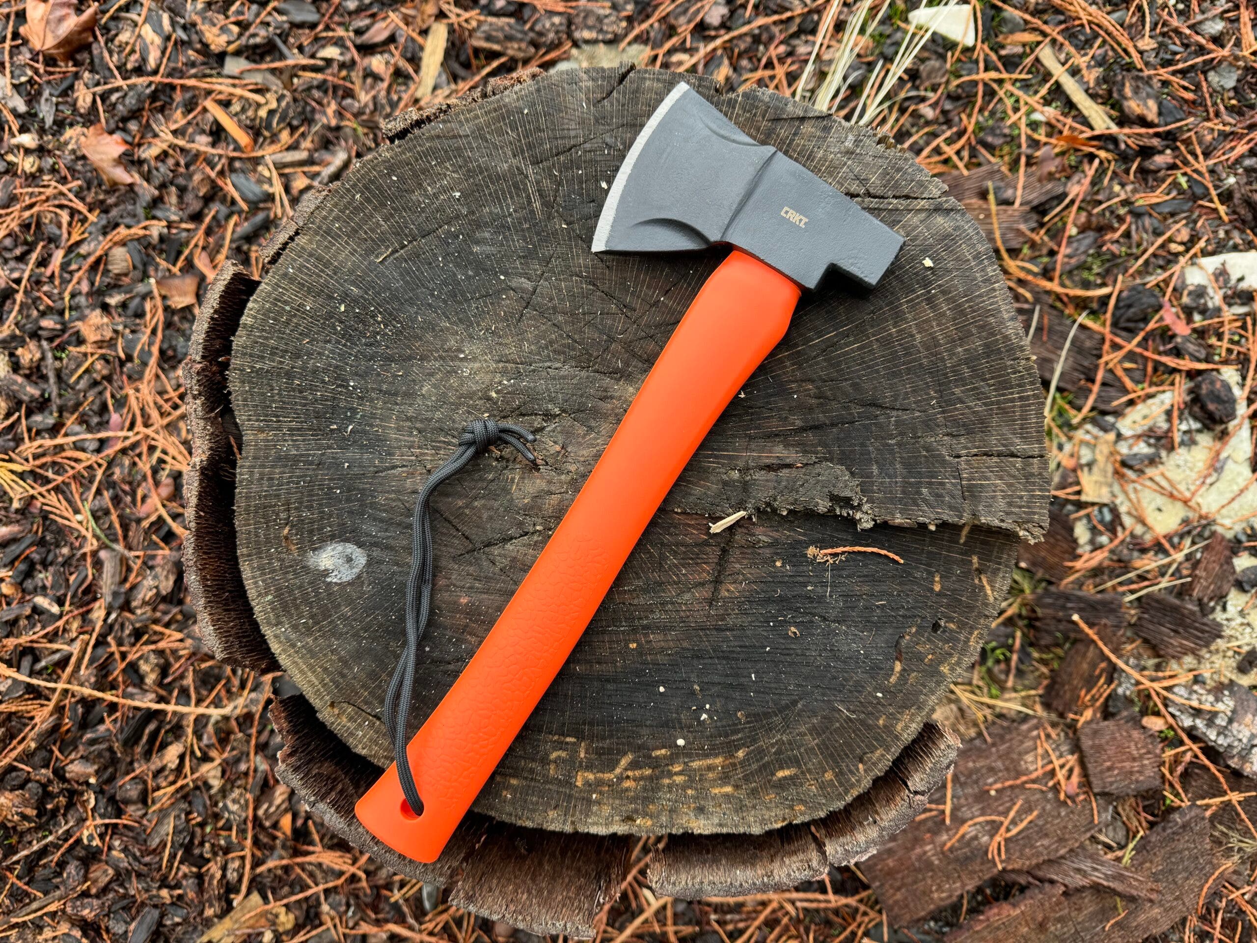 orange handled hatchet on top of wood stump outside, best value hatchet