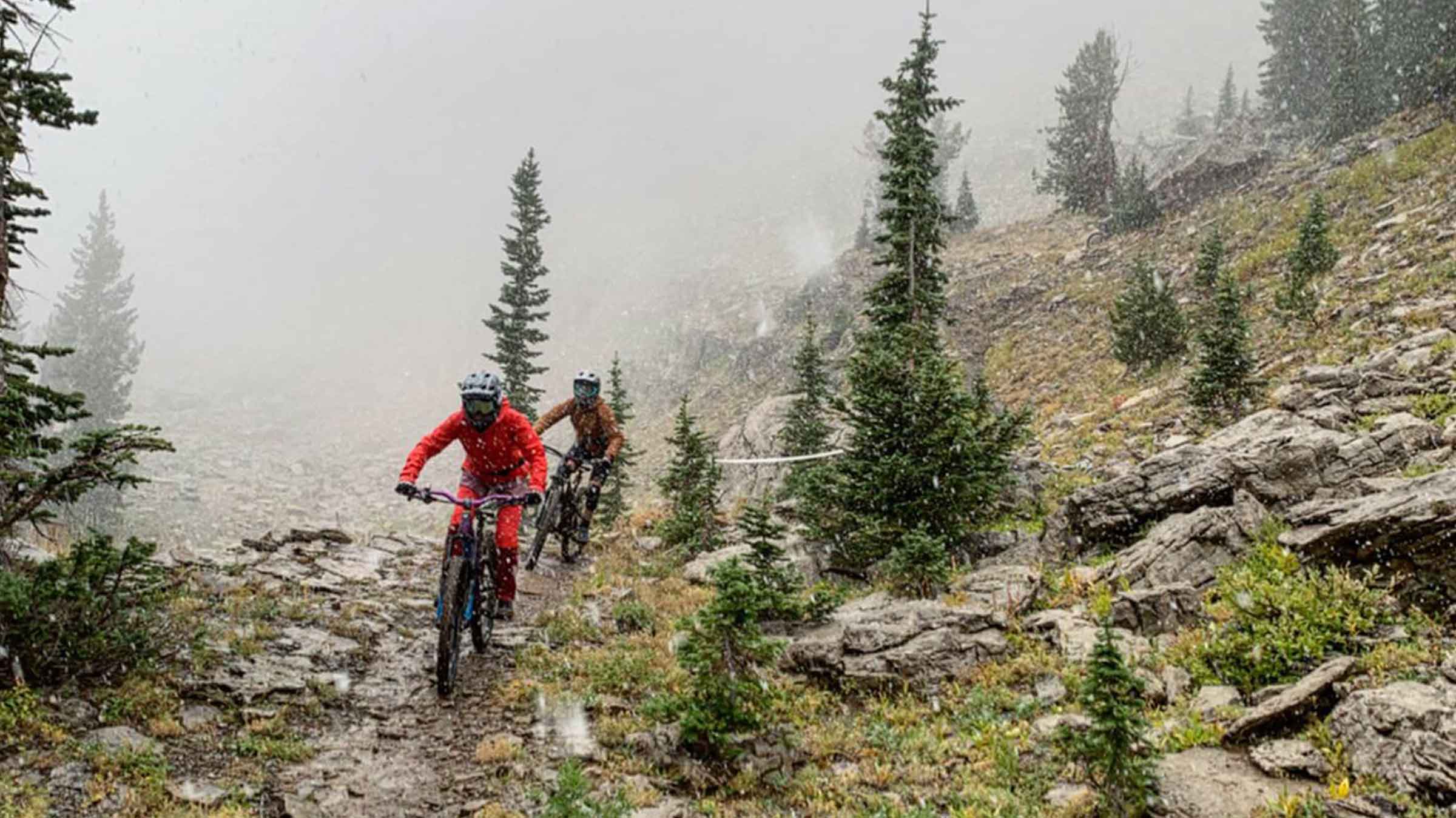Two people mountain biking in the snow