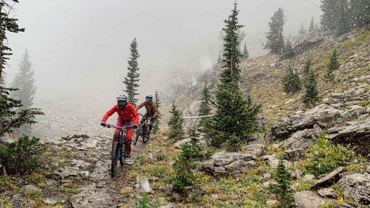 Two people mountain biking in the snow