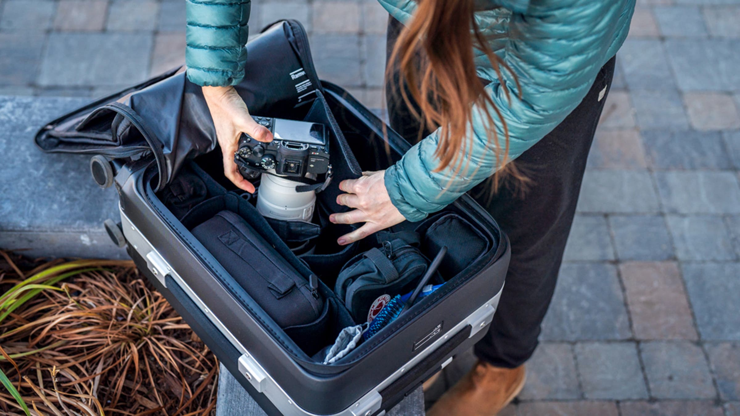 Closeup of woman putting camera in travel suitcase