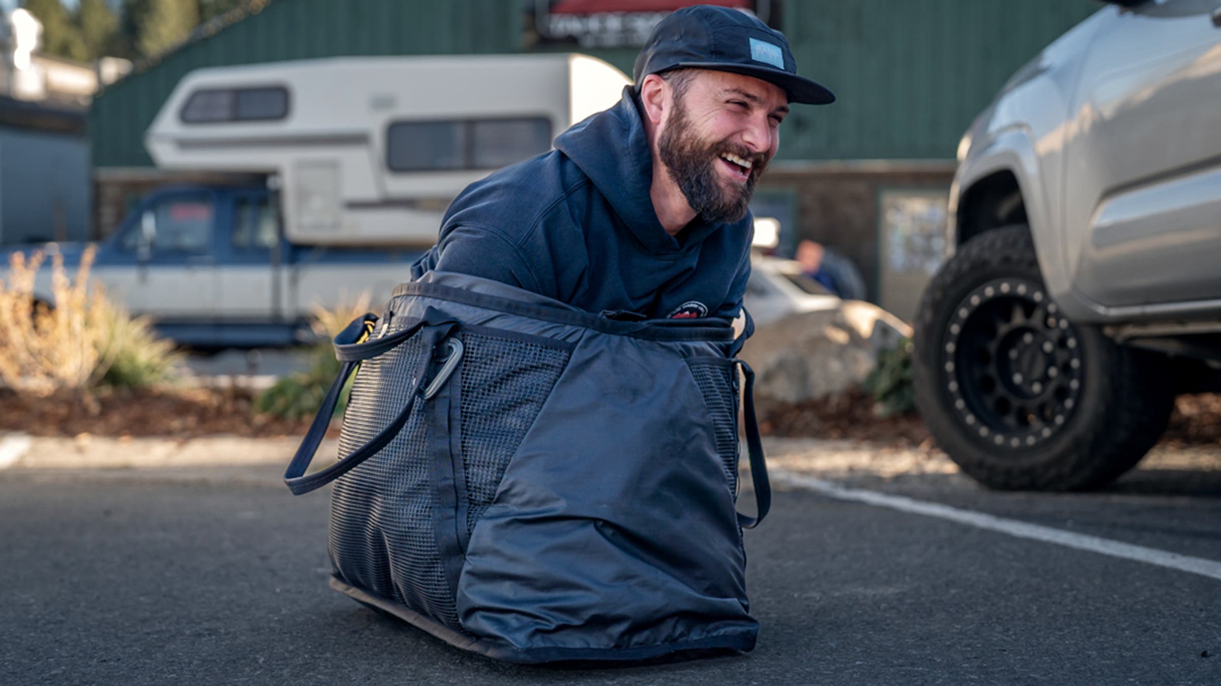 Man squeezing into Evo Gear Tote bag in parking lot