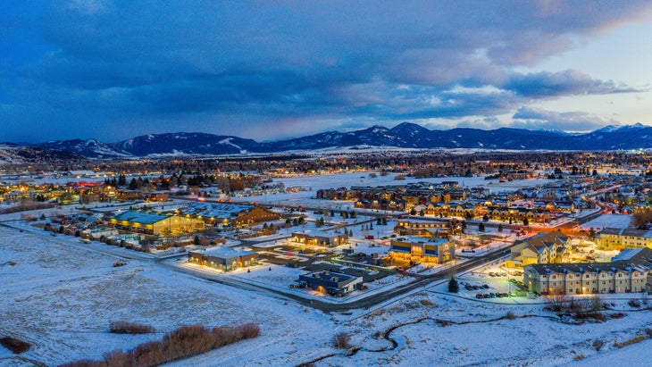 Bozeman from above at dusk, lights everywhere and a little snow