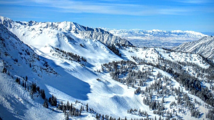 An aerial view of Utah’s Brighton Resort, covered in snow, with blue skies above.