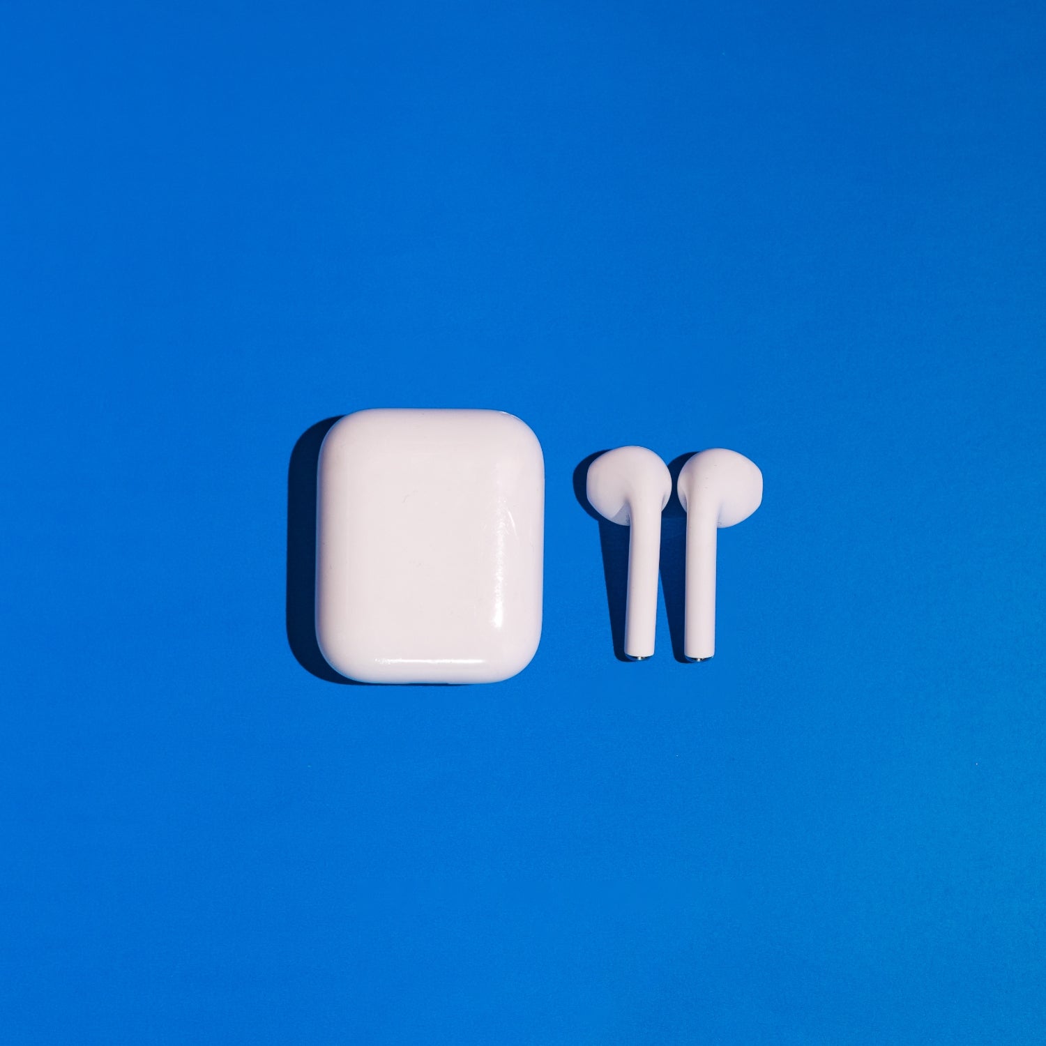 Wireless white headphones on blue background.