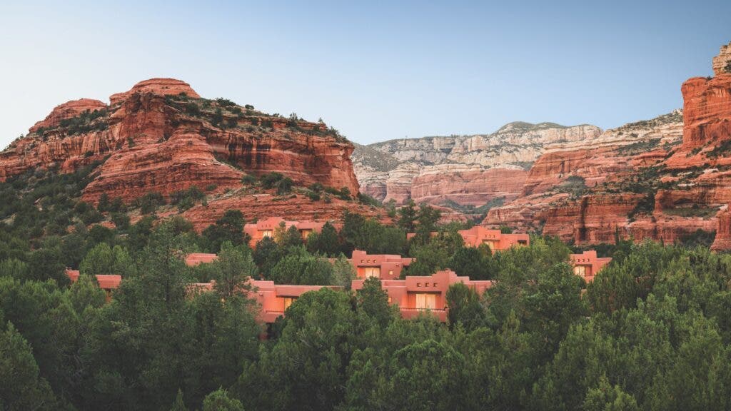 A bird's-eye view of the Enchantment Resort casitas amid pine trees and backed by the high walls of Boynton Canyon
