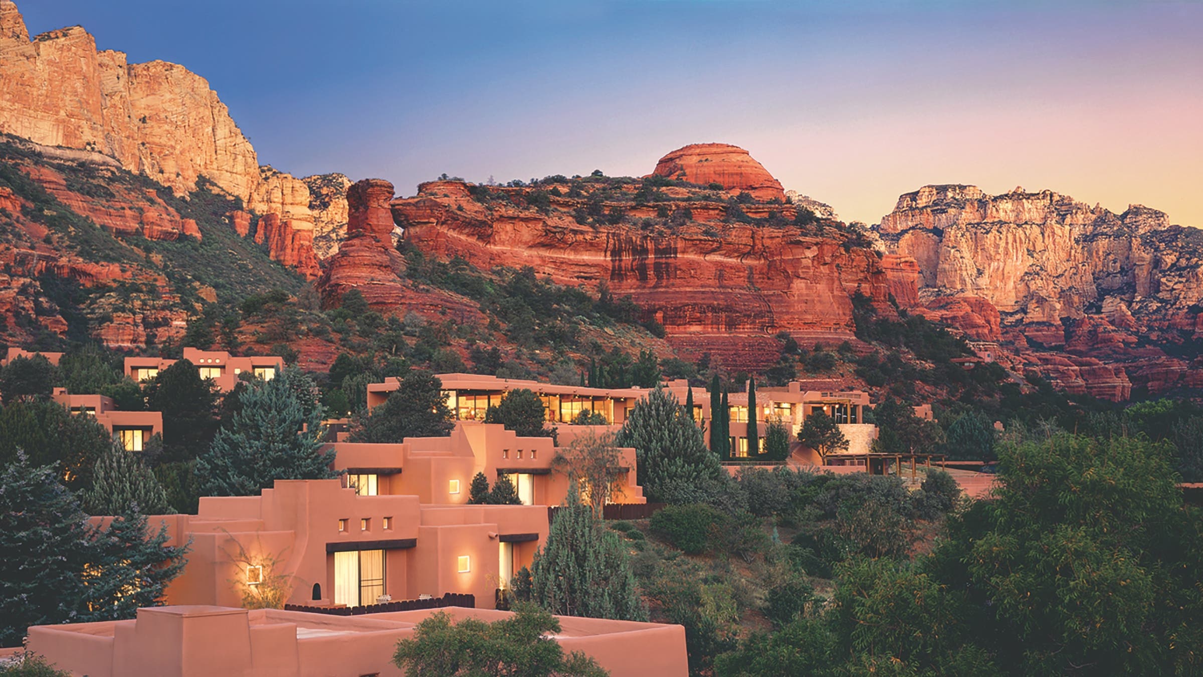 Southwestern pueblo architecture casitas nestled directly against Boynton Canyon red rocks in Sedona