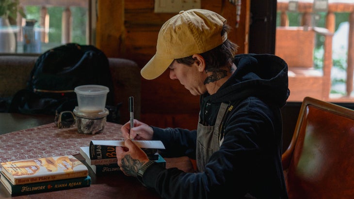 a person in a yellow hat sits at a cabin table