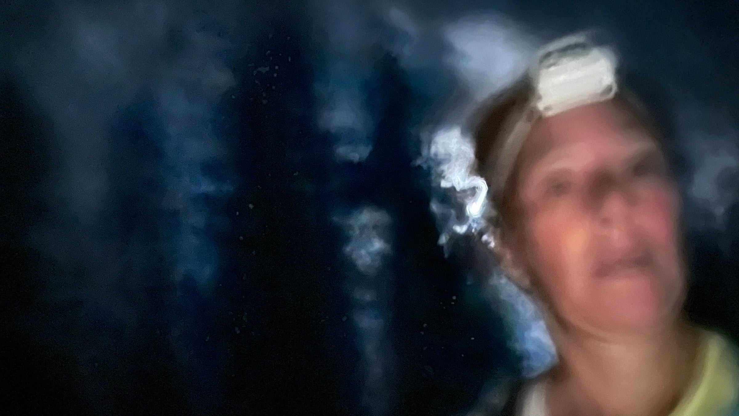 blurry runner wearing headlamp running in the dark