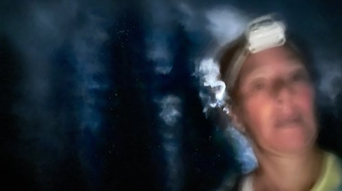 blurry runner wearing headlamp running in the dark