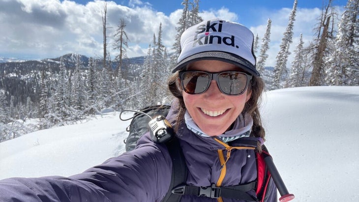 The author wearing a ball cap that reads "Be Kind" and a ski jacket and backpack, shooting a selfie in a snow-covered setting in Utah’s backcountry