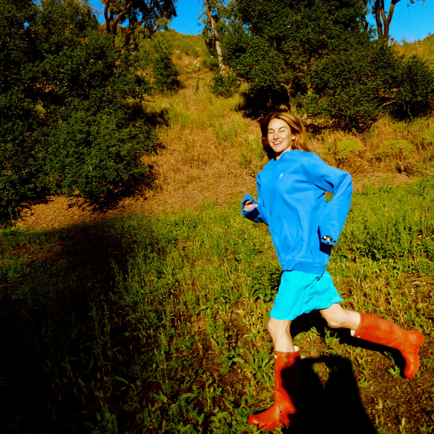 Woodley in Malibu, California, in June. Sweatshirt by Patagonia, Slip by Araks, and Rain Boots by Hunter.