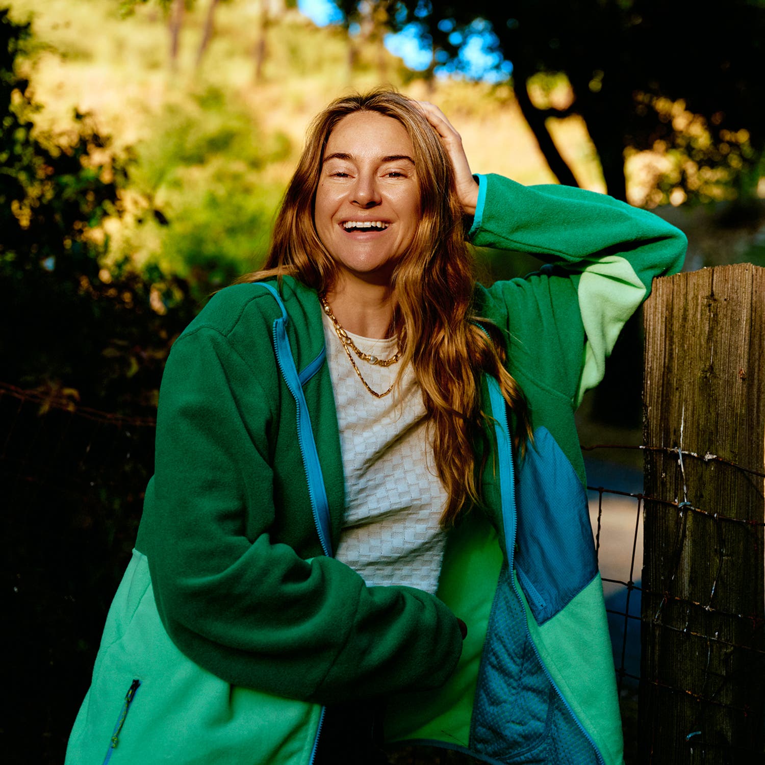 Shailene Woodley laughing outside. Fleece by Patagonia, Cashmere Checker Baby Tee by Guest in Residence, jewelry by Handle Only with Love